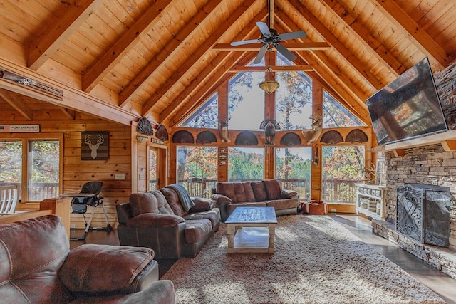 living room featuring a stone fireplace, wood walls, wood ceiling, hardwood / wood-style flooring, and beam ceiling