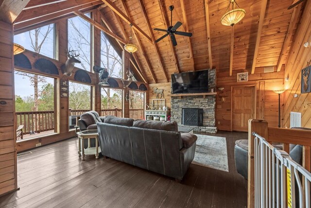 living room featuring wood ceiling, hardwood / wood-style flooring, beam ceiling, a fireplace, and wood walls