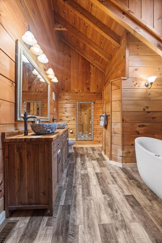 laundry area featuring cabinets, wooden walls, and washer and clothes dryer