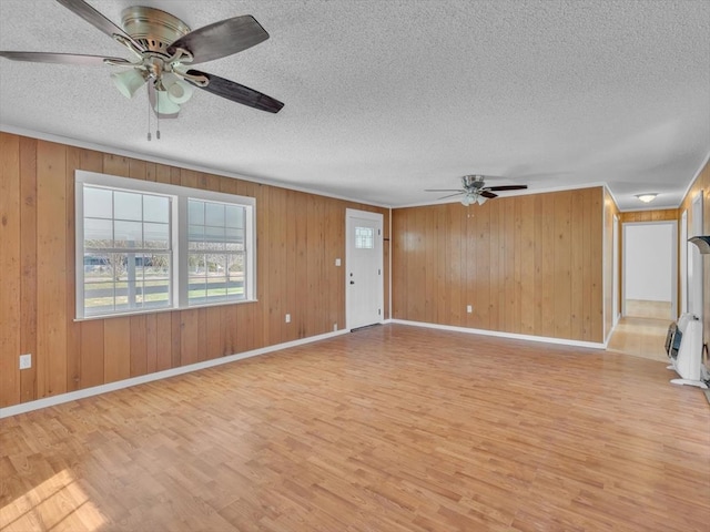 104 Riverview Dr, Dalton, GA 30721 - unfurnished living room featuring light wood finished floors, a ceiling fan, a textured ceiling, baseboards, and wood walls