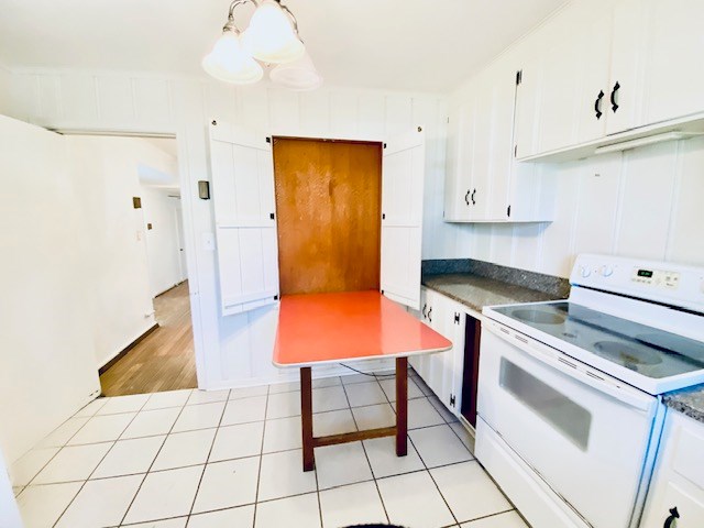 503 Williamsburg Dr, Dalton, GA 30720 - kitchen featuring dark countertops, white cabinets, light tile patterned floors, and white range with electric stovetop