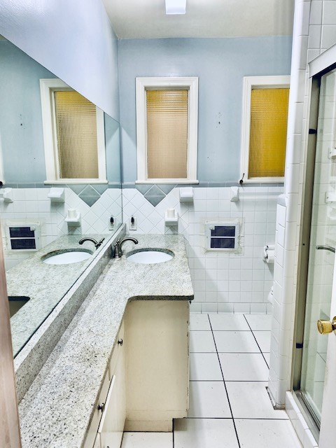 503 Williamsburg Dr, Dalton, GA 30720 - bathroom with a sink, tile walls, a stall shower, and tile patterned flooring