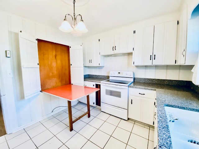 503 Williamsburg Dr, Dalton, GA 30720 - kitchen with white electric range, decorative light fixtures, a chandelier, and white cabinetry