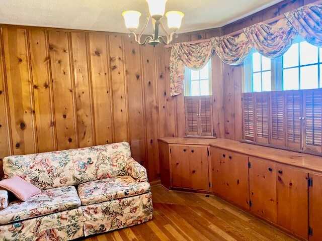 503 Williamsburg Dr, Dalton, GA 30720 - unfurnished room with wood finished floors, wooden walls, and a chandelier