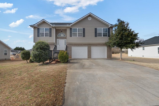 raised ranch featuring a garage and a front yard