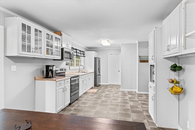 kitchen featuring crown molding, appliances with stainless steel finishes, sink, and white cabinets