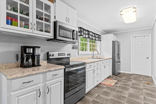 kitchen with sink, crown molding, white cabinetry, stainless steel appliances, and light stone countertops