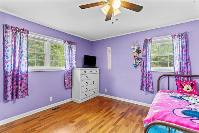 bedroom with crown molding, hardwood / wood-style floors, and ceiling fan