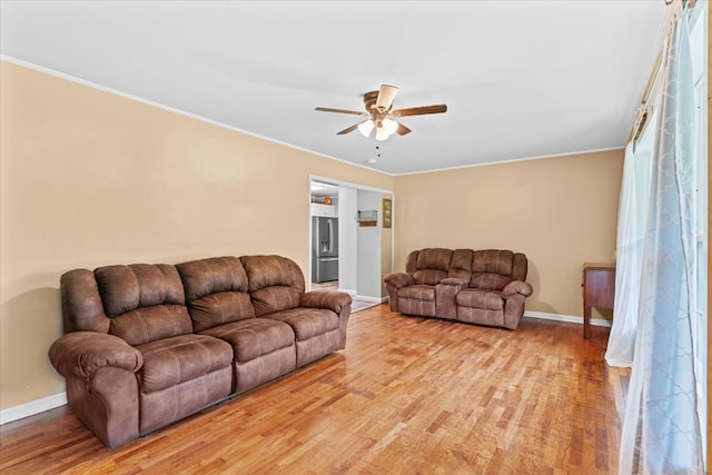 living room with crown molding, ceiling fan, and light wood-type flooring