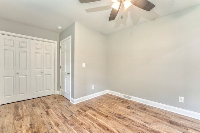 unfurnished bedroom featuring ceiling fan, a closet, and light hardwood / wood-style flooring