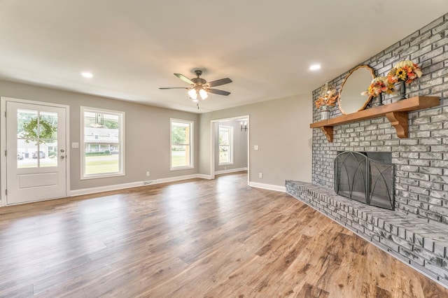 unfurnished living room featuring hardwood / wood-style flooring, a fireplace, and ceiling fan