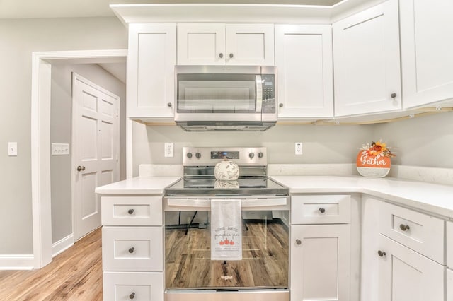 kitchen featuring stainless steel appliances, light hardwood / wood-style floors, and white cabinets