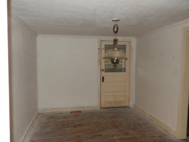 empty room featuring crown molding, wood finished floors, baseboards, and a textured ceiling