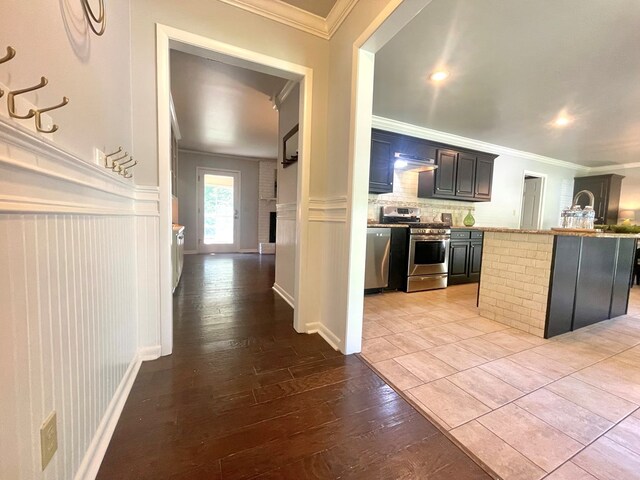 1229 Valencia Dr, Dalton, GA 30720 - kitchen featuring crown molding, stainless steel appliances, backsplash, wainscoting, and hardwood / wood-style floors