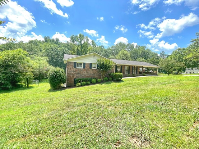 1229 Valencia Dr, Dalton, GA 30720 - single story home with a carport, a front lawn, brick siding, and view of wooded area