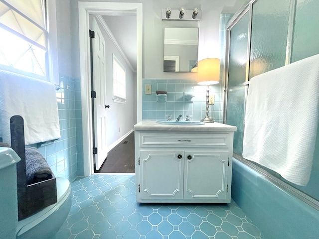1229 Valencia Dr, Dalton, GA 30720 - bathroom with vanity, crown molding, bath / shower combo with glass door, and tile walls