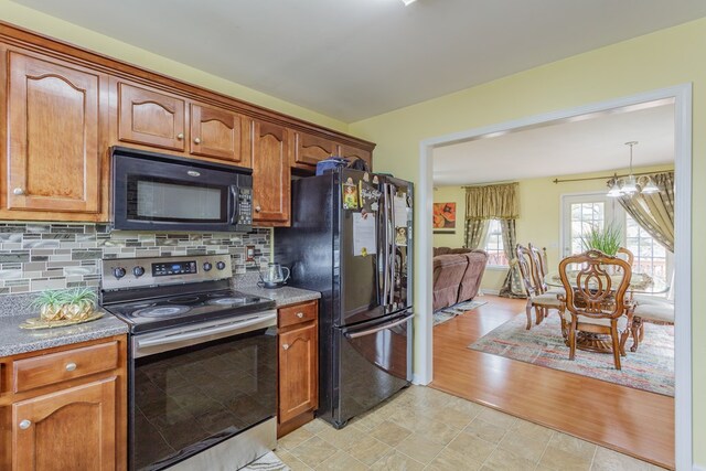 128 Andasol Way, Dalton, GA 30720 - kitchen featuring black appliances, an inviting chandelier, backsplash, and brown cabinets