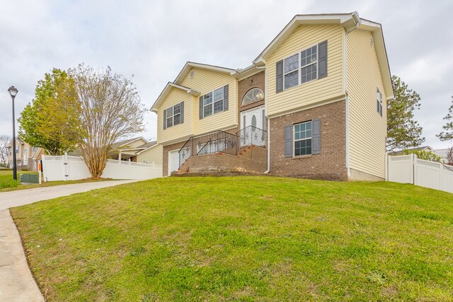128 Andasol Way, Dalton, GA 30720 - split foyer home with concrete driveway, fence, a front lawn, brick siding, and a garage