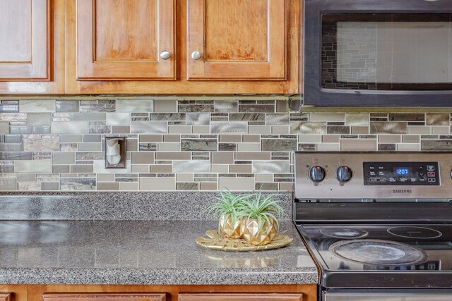 128 Andasol Way, Dalton, GA 30720 - details with tile countertops, stainless steel range with electric cooktop, brown cabinets, and decorative backsplash