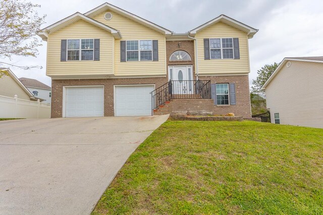 128 Andasol Way, Dalton, GA 30720 - raised ranch featuring an attached garage, brick siding, a front yard, and driveway