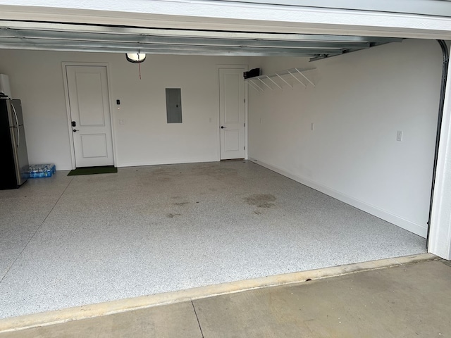 garage with a garage door opener, stainless steel fridge, and electric panel