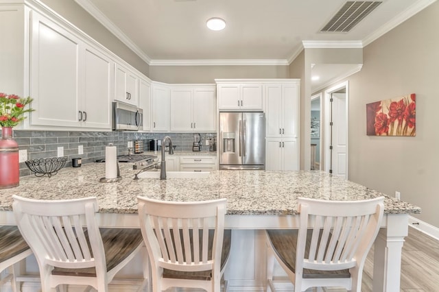 kitchen featuring white cabinetry, a breakfast bar, and appliances with stainless steel finishes