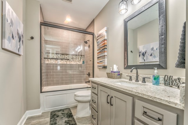 full bathroom with bath / shower combo with glass door, vanity, and toilet