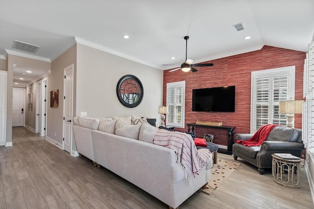 living room featuring plenty of natural light, vaulted ceiling, and light wood-type flooring