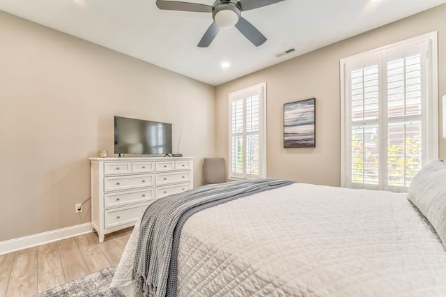 bedroom with multiple windows, light hardwood / wood-style flooring, and ceiling fan