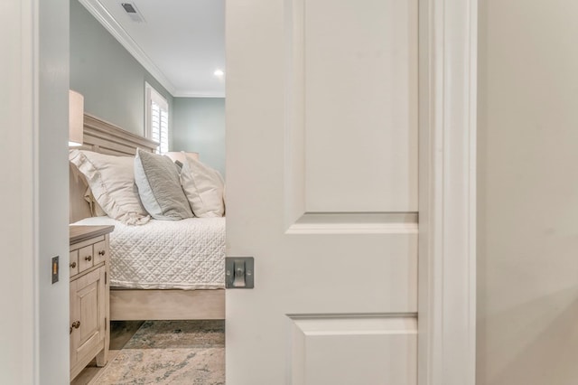 bedroom with hardwood / wood-style flooring and ornamental molding