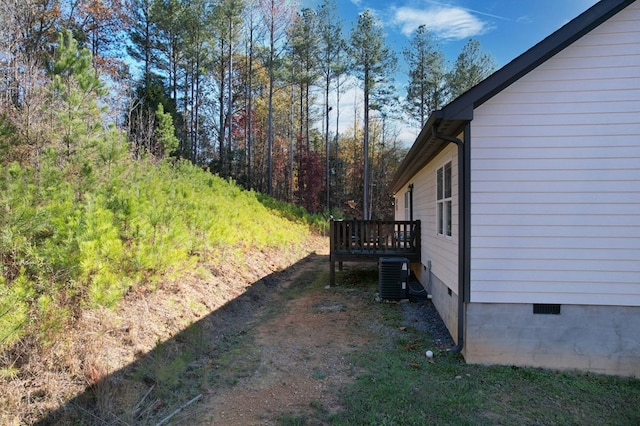 view of yard featuring central AC and a deck