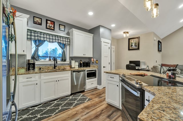 kitchen featuring sink, white cabinetry, stainless steel appliances, light hardwood / wood-style floors, and light stone countertops