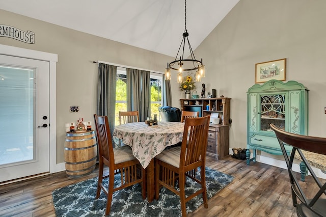 dining space featuring lofted ceiling, a notable chandelier, and dark hardwood / wood-style floors