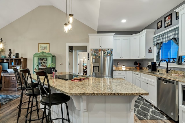 kitchen featuring white cabinetry, appliances with stainless steel finishes, a center island, and sink