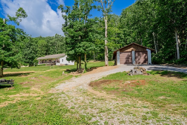 2163 Red Leaf Ln, Soddy Daisy, TN 37379 - view of grassy yard with an outbuilding, a wooded view, a detached garage, and driveway