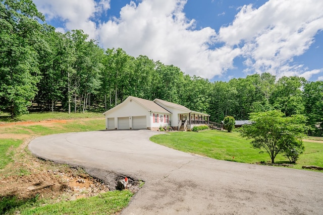 2163 Red Leaf Ln, Soddy Daisy, TN 37379 - view of front facade with a porch, a garage, a front yard, and curved driveway