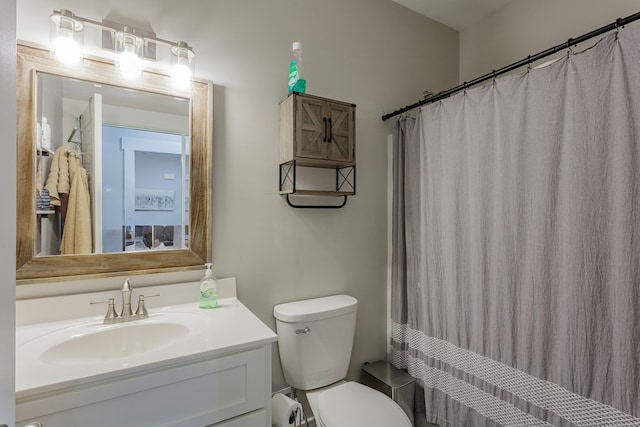 bathroom with walk in shower, vanity, and toilet