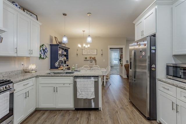 kitchen featuring light stone counters, sink, white cabinetry, and appliances with stainless steel finishes