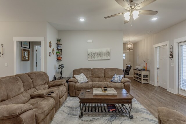 living room with ceiling fan and light hardwood / wood-style flooring