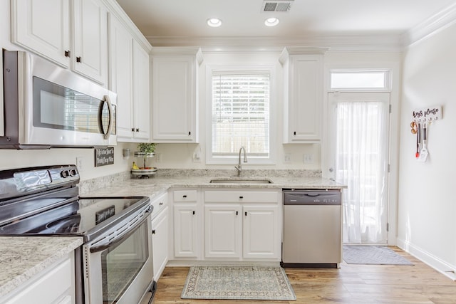 1951 Oxford Ct Unit 10, Dalton, GA 30720 - kitchen with stainless steel appliances, a sink, white cabinets, light wood-type flooring, and ornamental molding