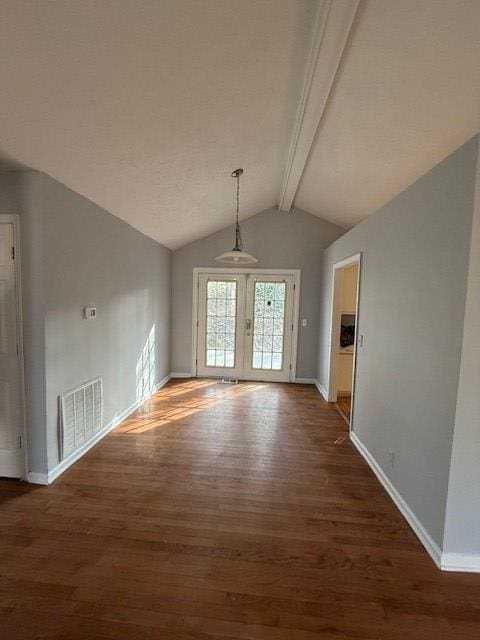 interior space with lofted ceiling with beams, dark hardwood / wood-style floors, and french doors