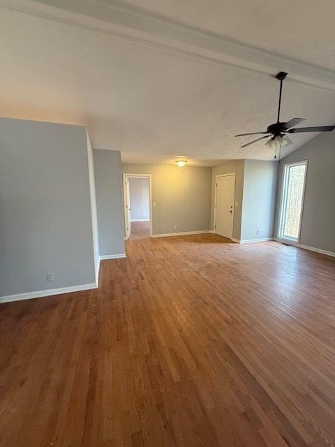 empty room with lofted ceiling with beams, ceiling fan, and light wood-type flooring