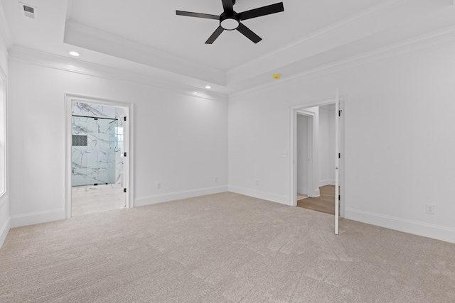 carpeted spare room with a tray ceiling, ornamental molding, and ceiling fan