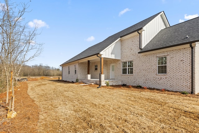 rear view of property with a porch and a yard