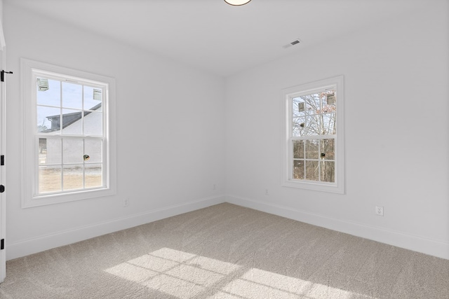 carpeted spare room featuring plenty of natural light