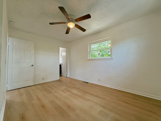 42 Travis Rd, Rossville, GA 30741 - unfurnished bedroom featuring light wood finished floors, a textured ceiling, baseboards, and a ceiling fan