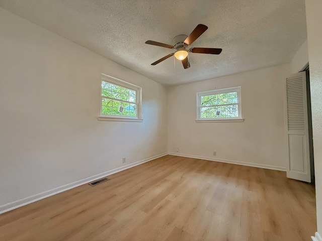 42 Travis Rd, Rossville, GA 30741 - unfurnished bedroom with a textured ceiling, light wood-type flooring, multiple windows, baseboards, and ceiling fan