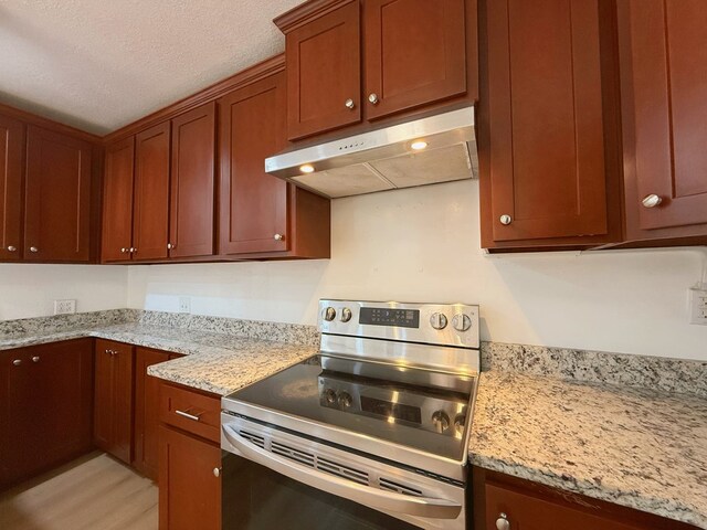 42 Travis Rd, Rossville, GA 30741 - kitchen with stainless steel electric range, under cabinet range hood, light stone counters, a textured ceiling, and light wood-type flooring