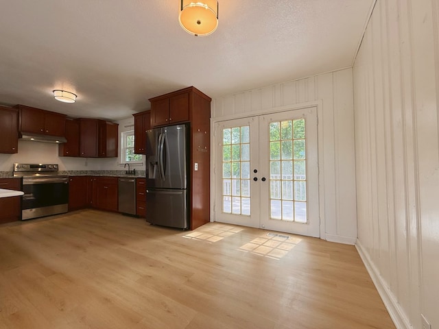 42 Travis Rd, Rossville, GA 30741 - kitchen featuring appliances with stainless steel finishes, french doors, light wood-style flooring, under cabinet range hood, and light countertops