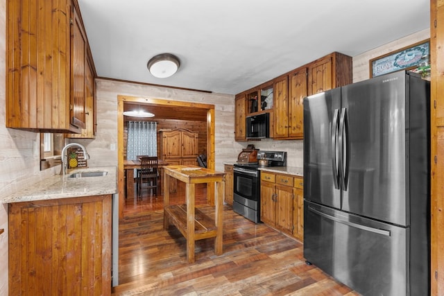 5120 Cleveland Hwy, Cohutta, GA 30710 - kitchen with stainless steel appliances, brown cabinetry, wood finished floors, tasteful backsplash, and light stone countertops